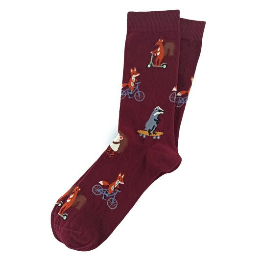Maroon socks with squirrel, fox, and badger riding scooter, bicycle, and skates – fun woodland animal design.