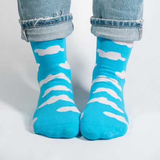 Float into the serene beauty of the sky with our White Clouds on Sky Blue Socks. These socks feature a dreamy pattern of fluffy white clouds against a calming sky blue backdrop, creating a tranquil and picturesque design.

Crafted for comfort and style, these socks are a breath of fresh air for your wardrobe. Whether you're strolling through the city or daydreaming in the countryside, our White Clouds on Sky Blue Socks are the perfect companion for an added touch of whimsy.

Step into the tranquility of the