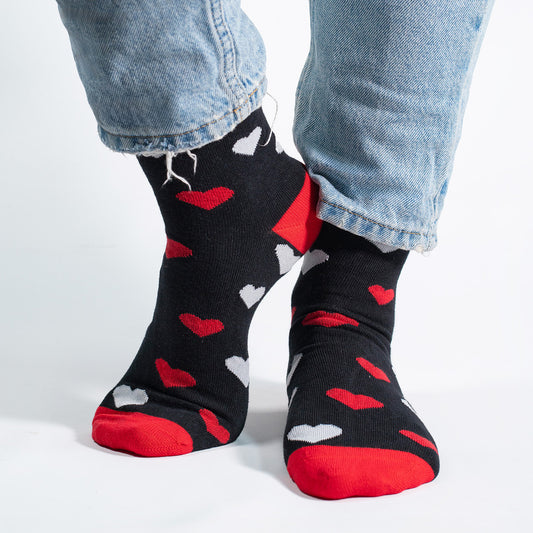 Unisex black socks with white and red hearts, perfect for Valentine’s Day or romantic occasions.